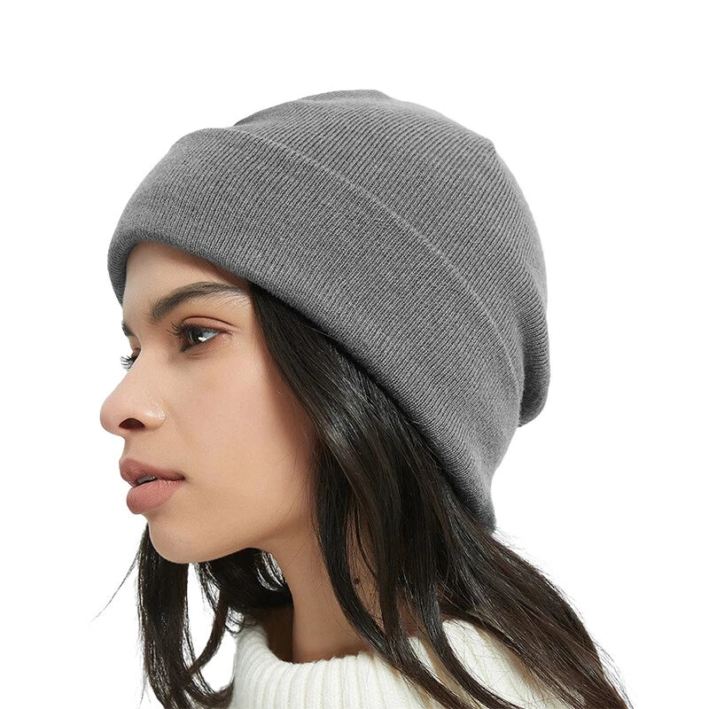 Woman wearing a gray knit beanie on a white background